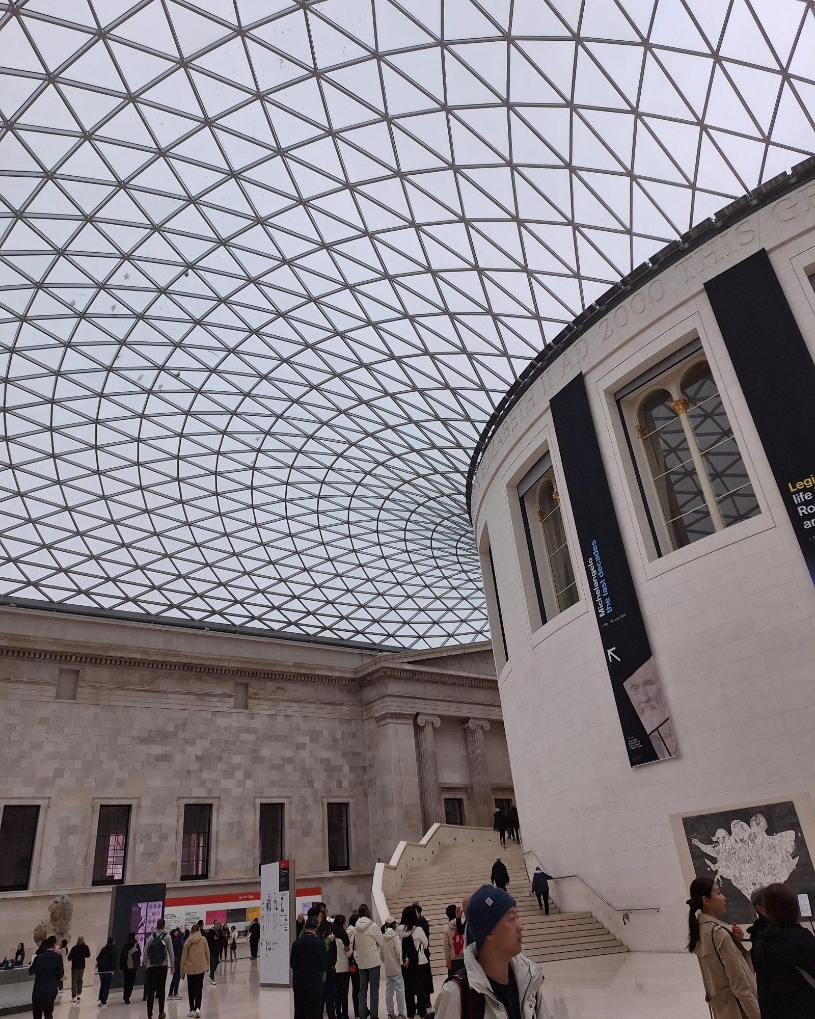 Interior of the British Museum with visitors standing under the glass roof