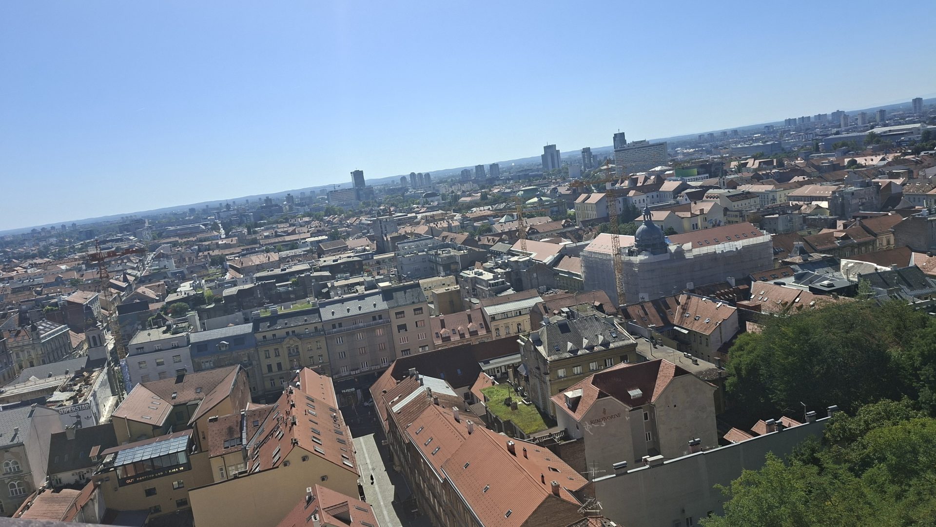 Wide city view of Zagreb with historic rooftops and modern buildings in the distance.